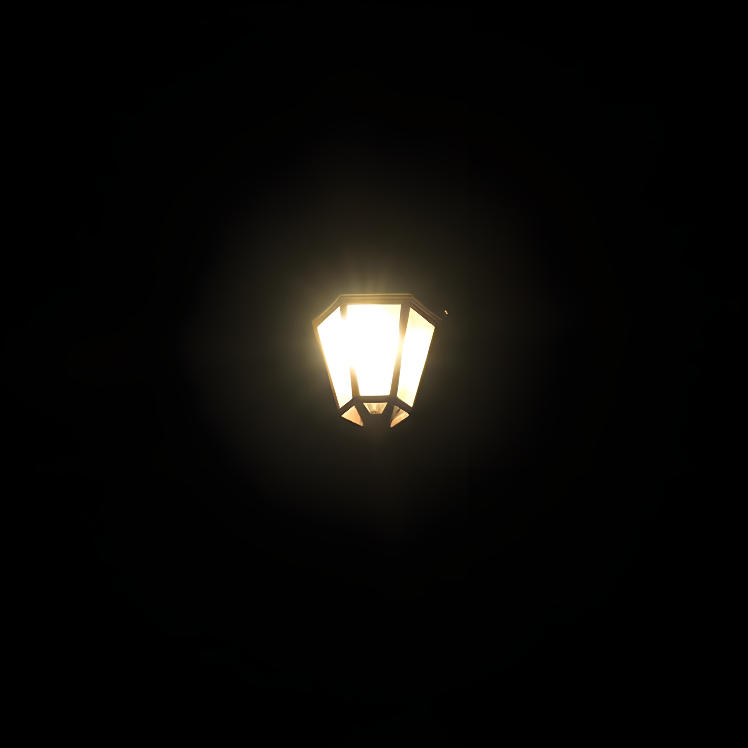 Réverbère lumineux brillant dans l’obscurité totale, symbolisant la lumière et la guidance dans l’obscurité spirituelle.
